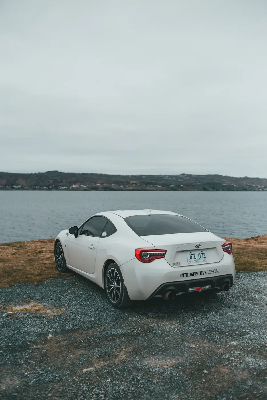 Coupé blanco aparcado junto a una cala
